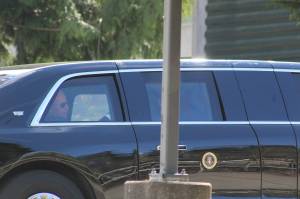 A man who appears to be President Joe Biden is seen in the back seat of a car in the presidents motorcade, departing the Green River College after the presidents speech. Photo by Alex Bruell/Sound Publishing