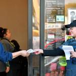 Joanne Fisher, right, a meat wrapper with the Marysville Albertsons, hands a leaflet to a shopper during an informational campaign on Wednesday. Fisher was one of less than a dozen grocery store workers handing out leaflets to shoppers about the proposed merger between Albertsons and Kroger. (Mike Henneke / The Herald)