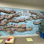 Artwork in the front office shows how KidVantage breaks down the work by teams. Some are the shoe team, diaper team and toy team. (Photo by Cameron Sires)