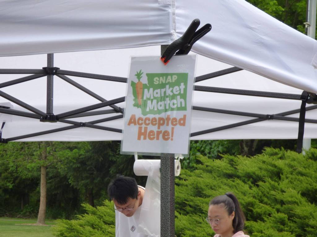 Stands with the Supplemental Nutrition Assistance Program (SNAP) Market Match sign allows people to increase the purchasing power of SNAP when purchasing fruits and vegetables at the Issaquah Farmers Market. The program will provide $1 for every SNAP $1 spent on fruit and vegetables  up to $25 per day per customer. SNAP-eligible items include fresh fruits, vegetables, mushrooms, fresh herbs and edible plant starts. (Cameron Sires/ Sound Publishing)