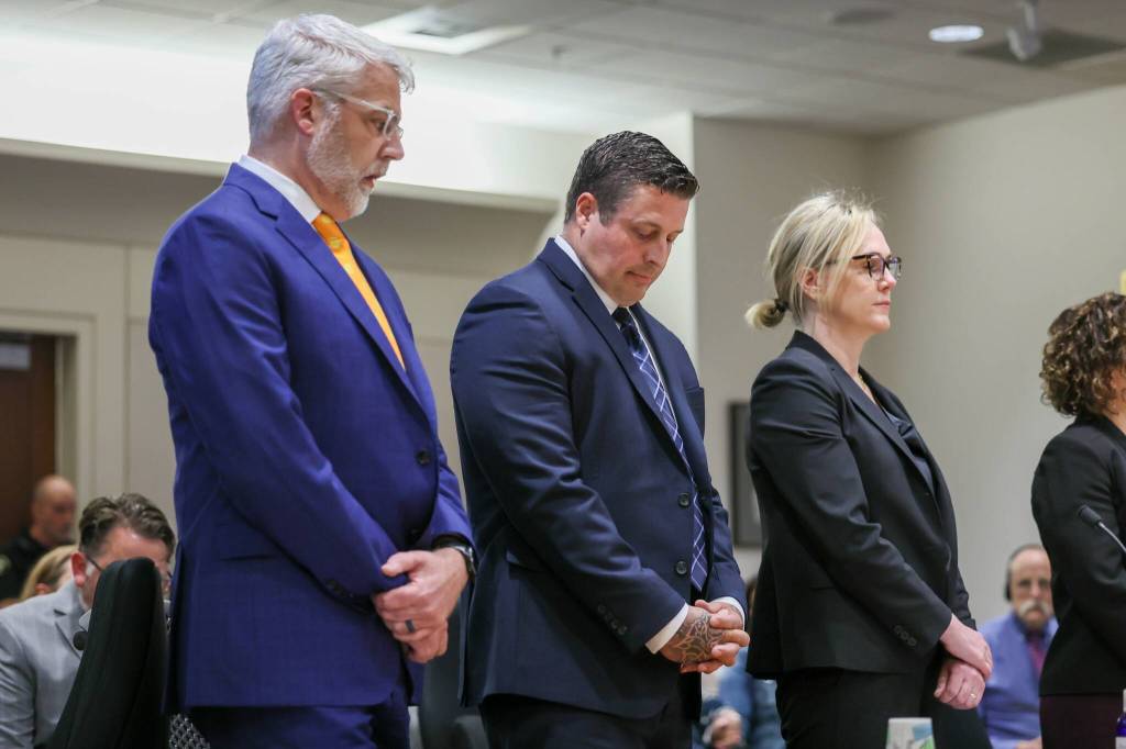 Auburn Police Officer Jeffrey Nelson, flanked by attorneys, stands as two guilty verdicts are handed down June 27 at the King County Maleng Regional Justice Center in Kent. (Ken Lambert / The Seattle Times / Pool)